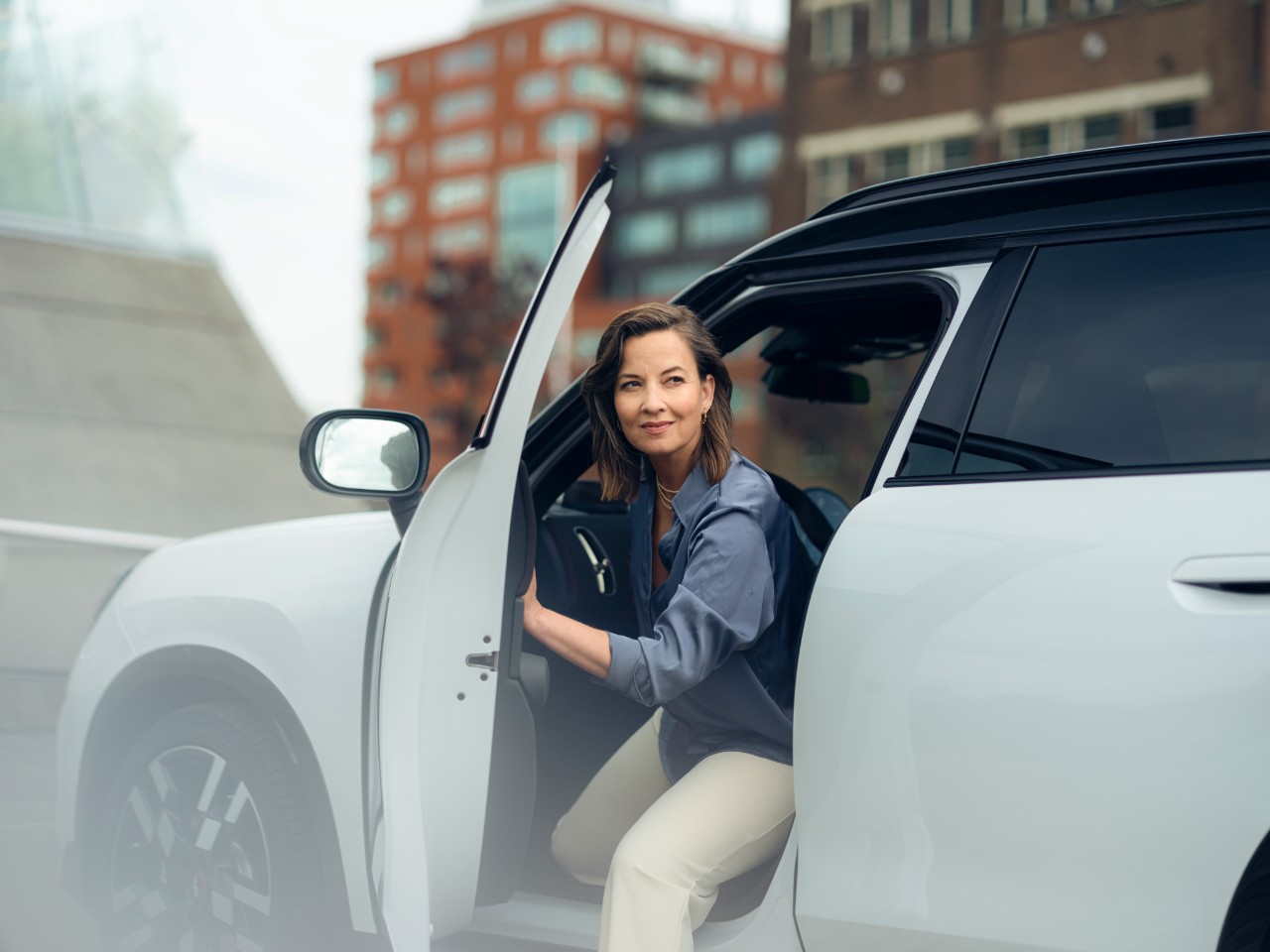 Woman opening door as she gets out of car.